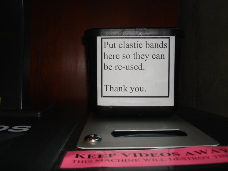 Sign asking people to return elastic bands in a box so they can be reused