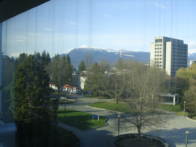 View from Koerner Library window showing UBC campus and mountains in background.