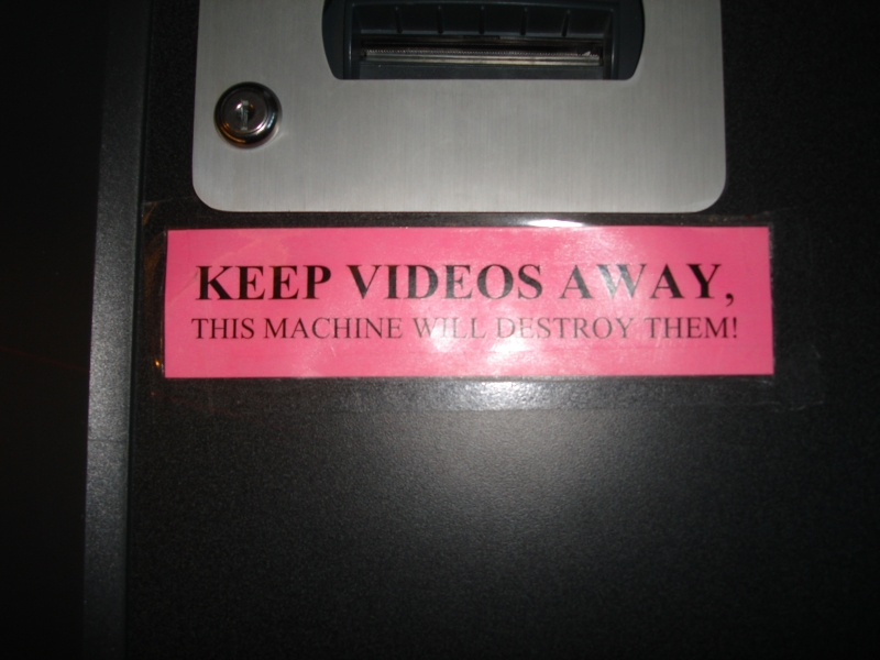 Sign warning not to put videos through the self-checkout machine